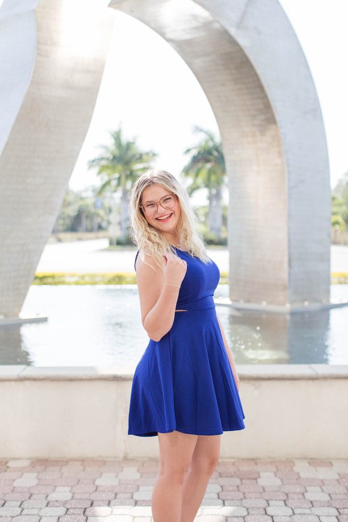 Girl smiling on FGCU campus for graduation pictures.