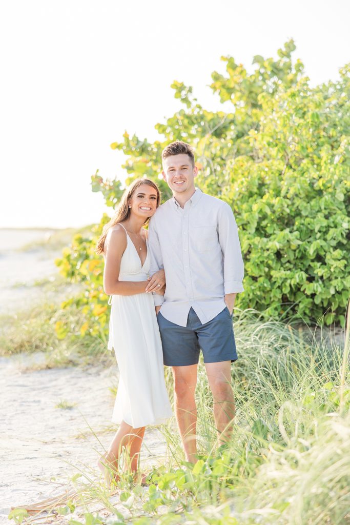 A couple smiling during their engagement pictures on Lido Key Beach in Sarasota, Florida. 