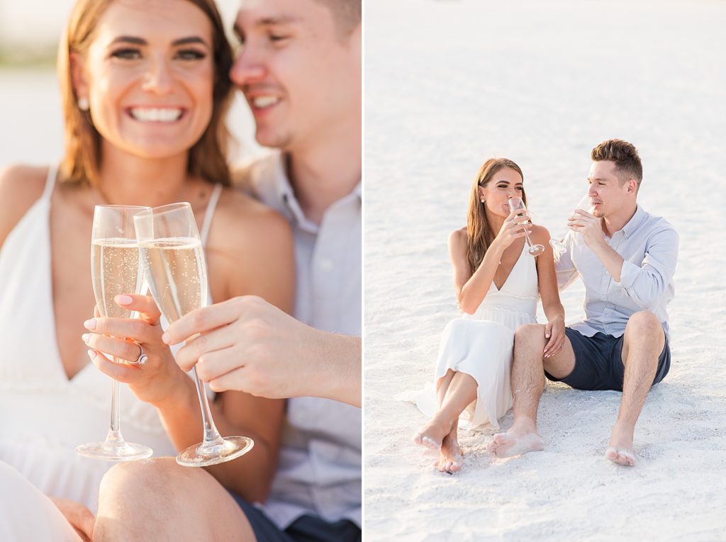 A couple drinking champagne on the beach during their Lido Key engagement session. 