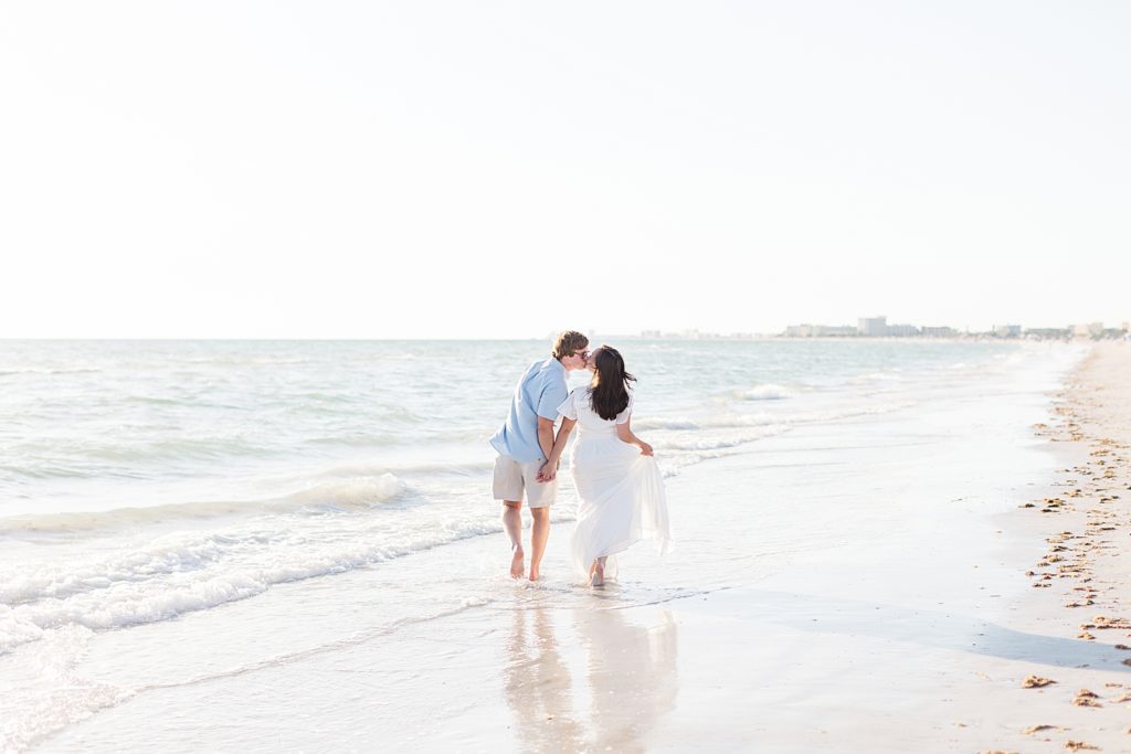 Couple walking down the beach on Treasure Island in St. Pete Florida.