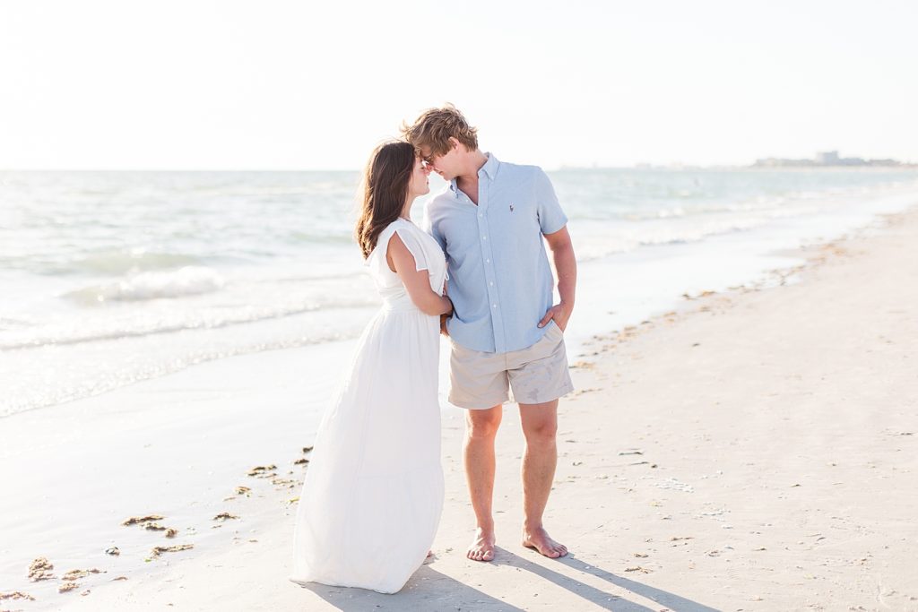 Couple standing on the beach during their engagement pictures.