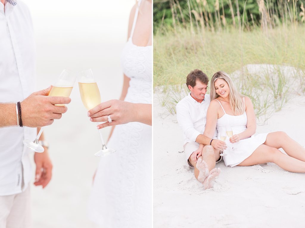 A couple clinging champagne glasses together while they sit on Fort Myers Beach. 
