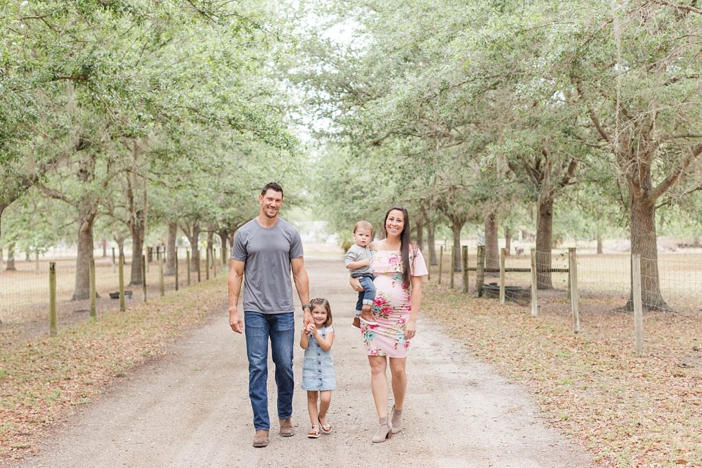 A family of four walking during their Estero Maternity Session. 