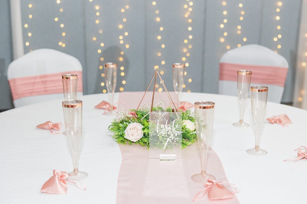 A wedding table decorated with white and pink linens. 