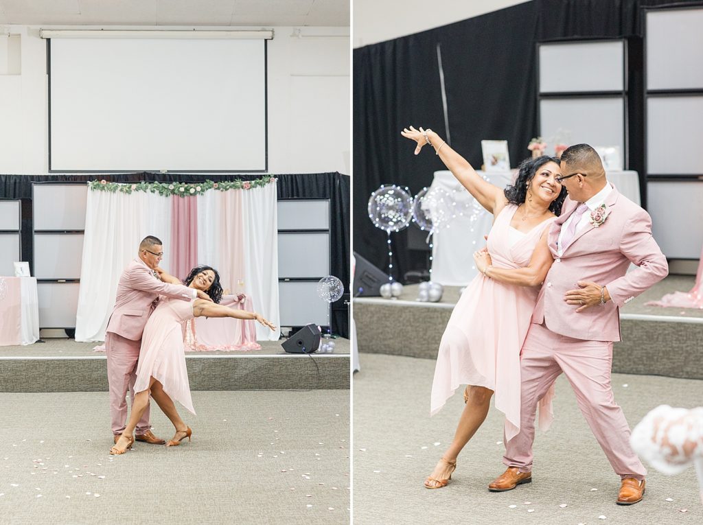 A bride and groom dancing while wearing a pink dress and pink tux. 