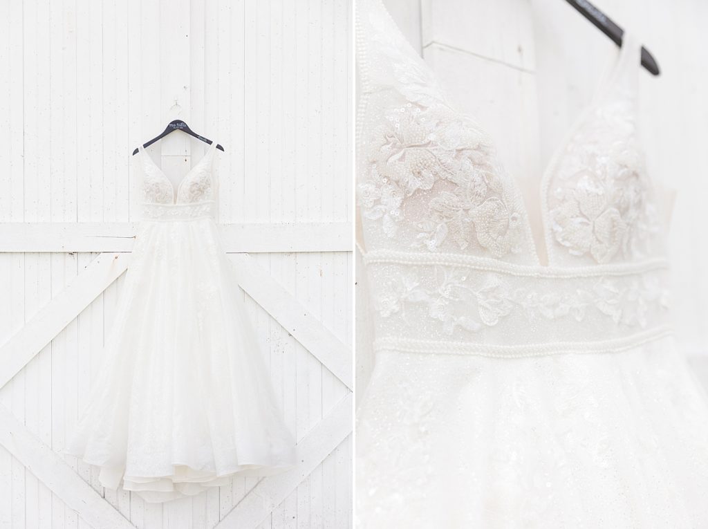 Picture of brides dress hanging on white barn doors. 