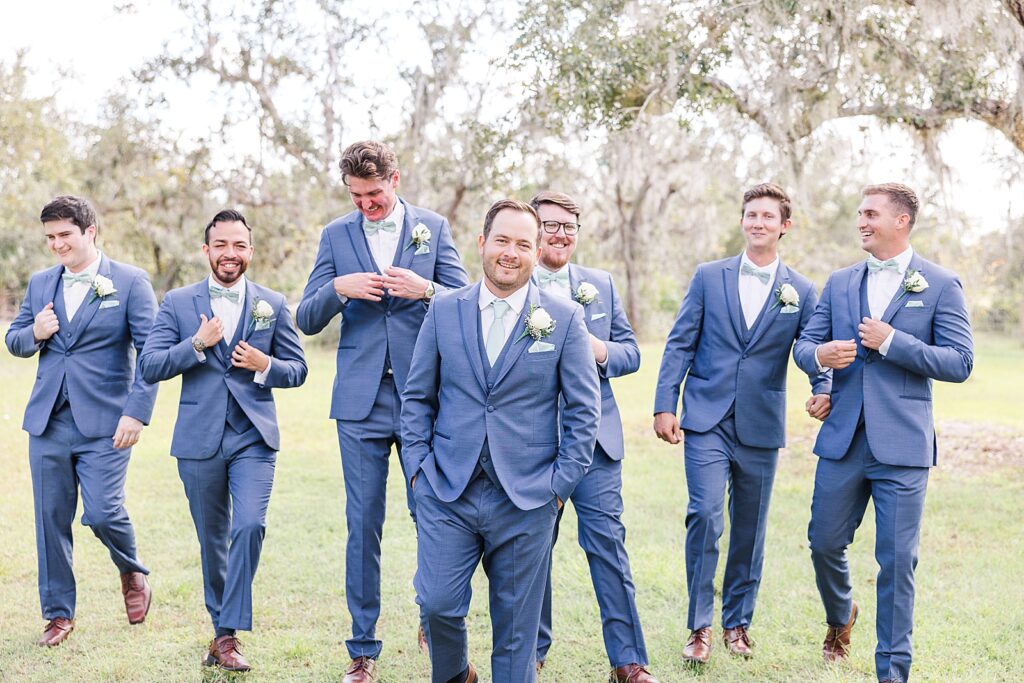 The groom and groomsmen walking and laughing. 