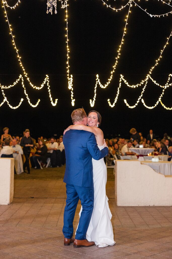 The bride and grooms first dance under twinkle lights. 