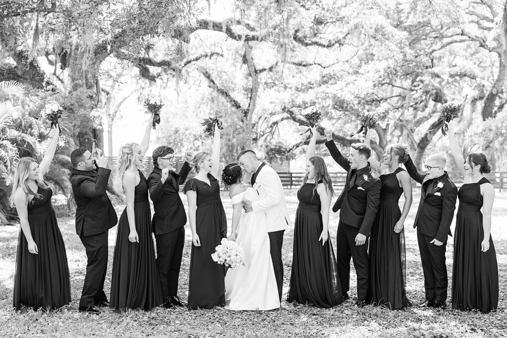 A black and white picture of the bridal party cheering. 