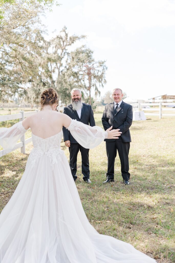Bride sharing a first look with her father and father-in-law. 