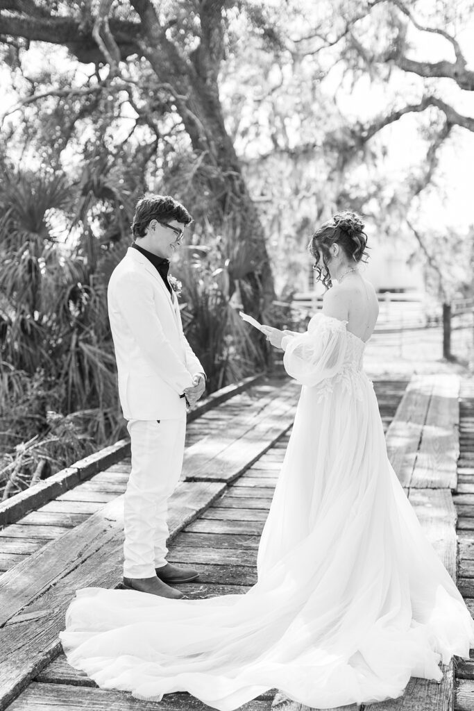 A black and white photo of the bride and groom sharing personal vows. 