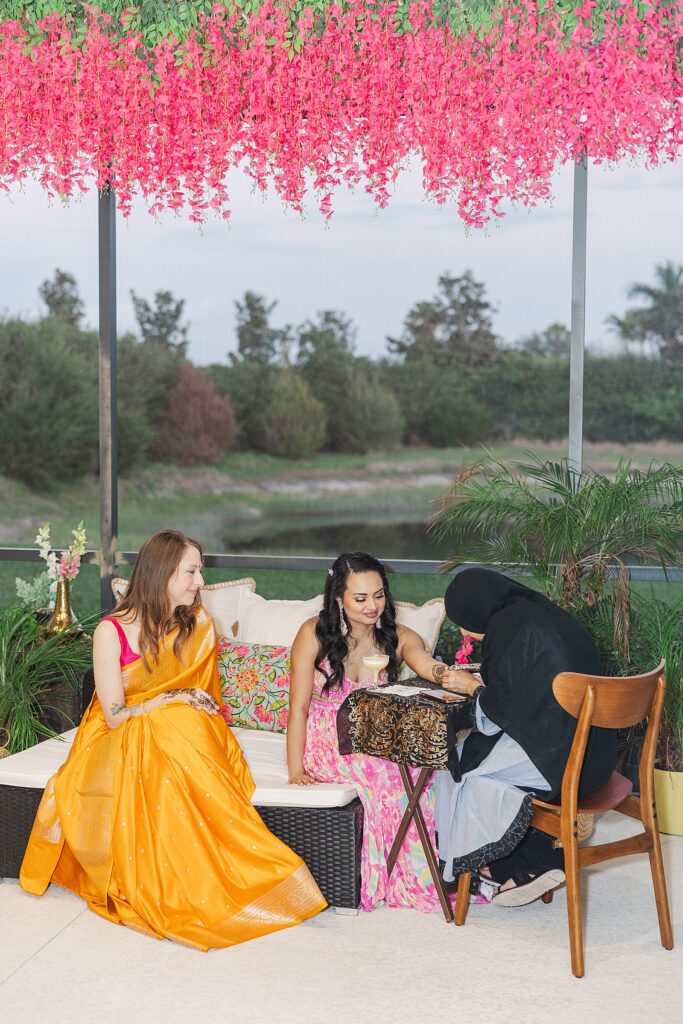 Indian bride getting henna on her arms and hands at her Mehendi.