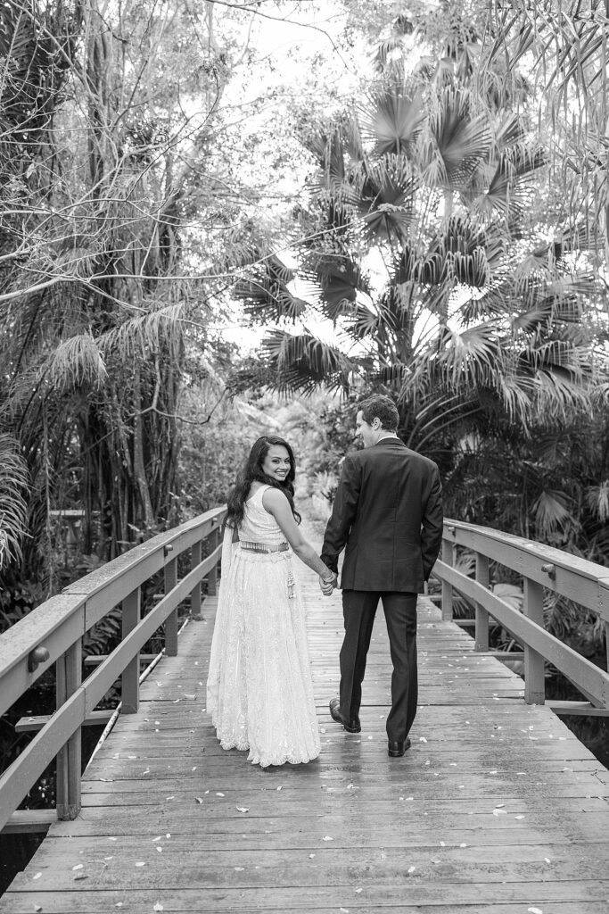 bride and groom walking across the bridge.