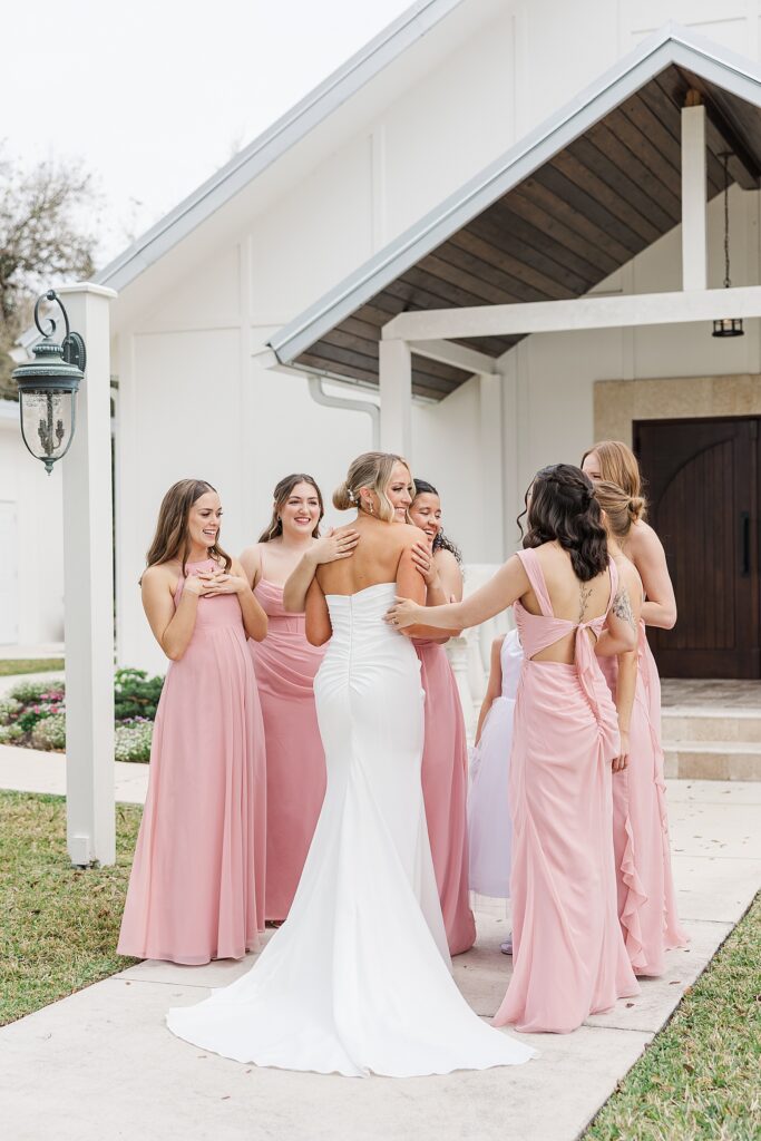 bride hugging bridsmaids