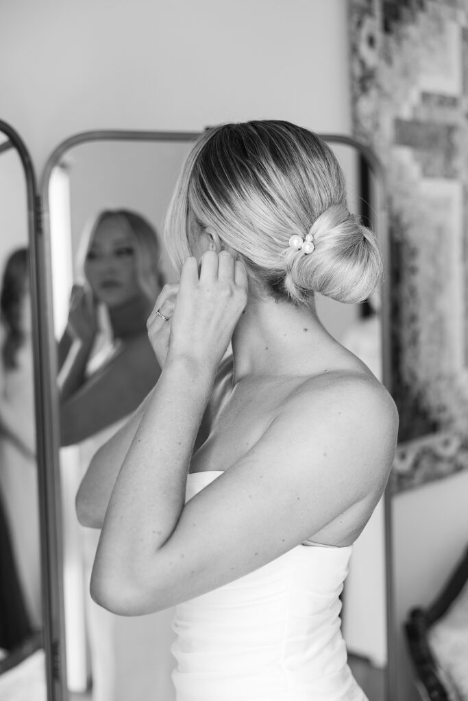 Bride putting her earrings on.